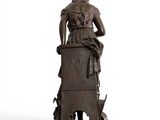 bronze statue of a woman sitting on a chair with a dog