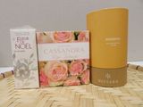 a bottle of perfume, a box of soap, and a box of soap on a table