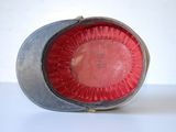 a red object in a metal container on a white surface