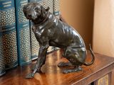 une statue représentant un chien assis au sommet d'une bibliothèque