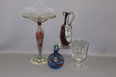 trois vases en verre posés sur une table, à côté d'un bougeoir en verre