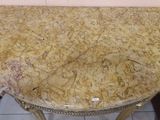 a table with a marble top on a tile floor