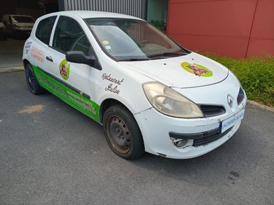 une petite voiture blanche garée devant un bâtiment