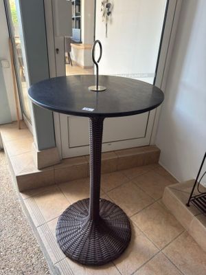 a black table with a candle on it in the middle of a room