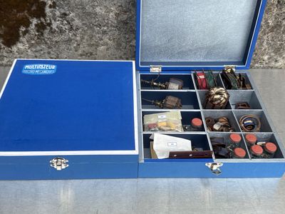 une boîte bleue remplie d'objets divers posée sur une table