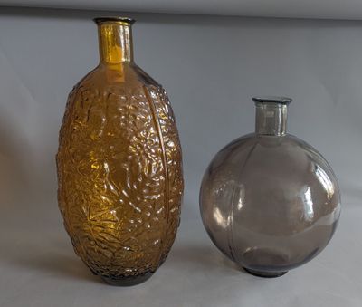 two glass vases sitting next to each other on a table