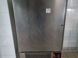 a small stainless steel refrigerator in a public restroom