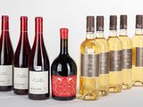 plusieurs bouteilles de vin sont alignées sur une surface blanche