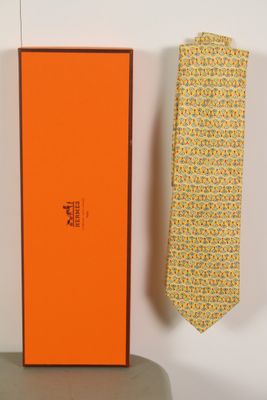 une boîte orange avec une cravate et une cravate jaune posées sur une table