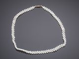 a white pearl necklace with a gold clasp