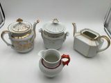 four different types of teapots on a white table