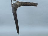 une sculpture en bronze représentant une chaussure posée sur un socle noir