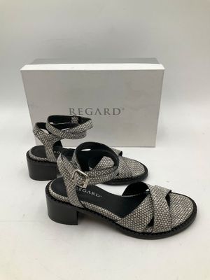 une paire de sandales noires et blanches posées sur une surface blanche