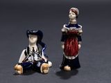 deux figurines représentant une femme et un homme assis l'un à côté de l'autre