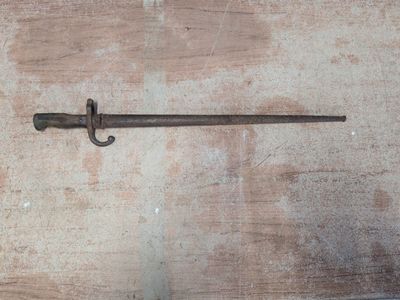 une petite épée posée sur une table en bois