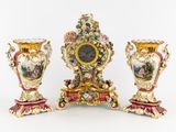 Trois vases sont posés sur une table, sur laquelle se trouve une horloge.