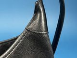 black leather handbag on a blue background