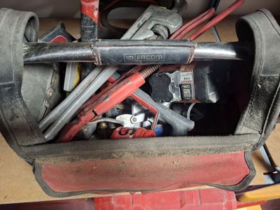 many tools in a tool bag on a table