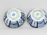 pair of blue and white vases with designs on them sitting on a table