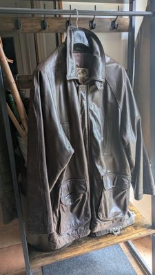une veste en cuir suspendue à un portant devant une vitrine