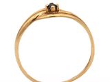 a close up of a gold ring with a black diamond on top