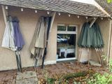 trois parapluies accrochés au mur d'un immeuble
