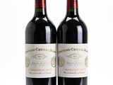 deux bouteilles de vin rouge posées l'une à côté de l'autre sur une surface blanche