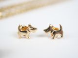 a close up of a pair of dog earrings on a white surface