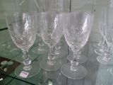 plusieurs verres à vin vides posés sur une étagère en verre dans une pièce