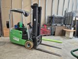 a green forklift in a warehouse with pallets in the background