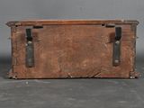 an old wooden box with metal handles on the floor