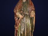 une vieille statue représentant un homme barbu vêtu d'une robe