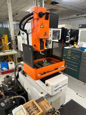 Une machine orange et noire se trouve dans une pièce où se trouvent de nombreuses autres machines