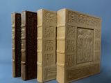 trois vieux livres ornés de gravures, posés les uns à côté des autres