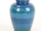 a blue vase that is sitting on a white surface