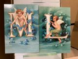 two cards with angels on them on a table