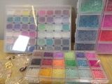 a lot of different colored beads in a box