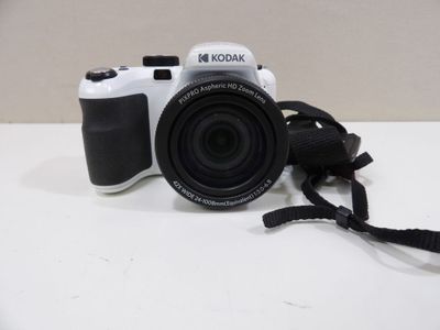 a white camera sitting on a table with a black strap