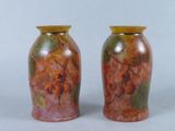 two vases sitting side by side on a white surface