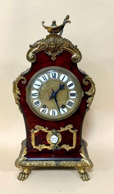 a small clock with a bird on top of it