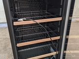 a black refrigerator with a glass door that has a bunch of shelves