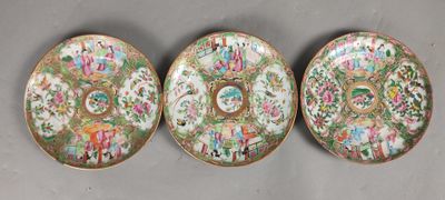three chinese famille plates with floral designs on them