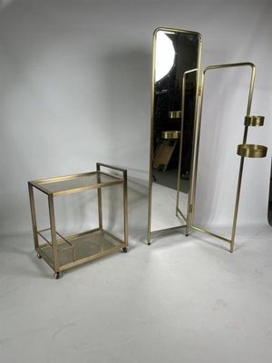 une paire de tables d'appoint en laiton et en verre et un miroir sur fond blanc