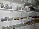 many glass jars and containers on the shelves in the kitchen