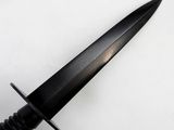 a close up of a knife on a white surface with a black handle