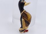 yellow and black duck figurine in a clear glass holder