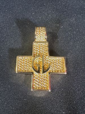 un gros plan d'une croix en or posée sur un tissu noir