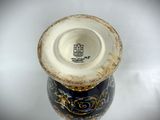 a blue and white vase with gold designs on it