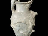 un vase blanc surmonté d'un oiseau