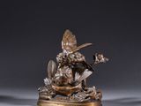 a bronze figurine of a woman with a bird and flowers